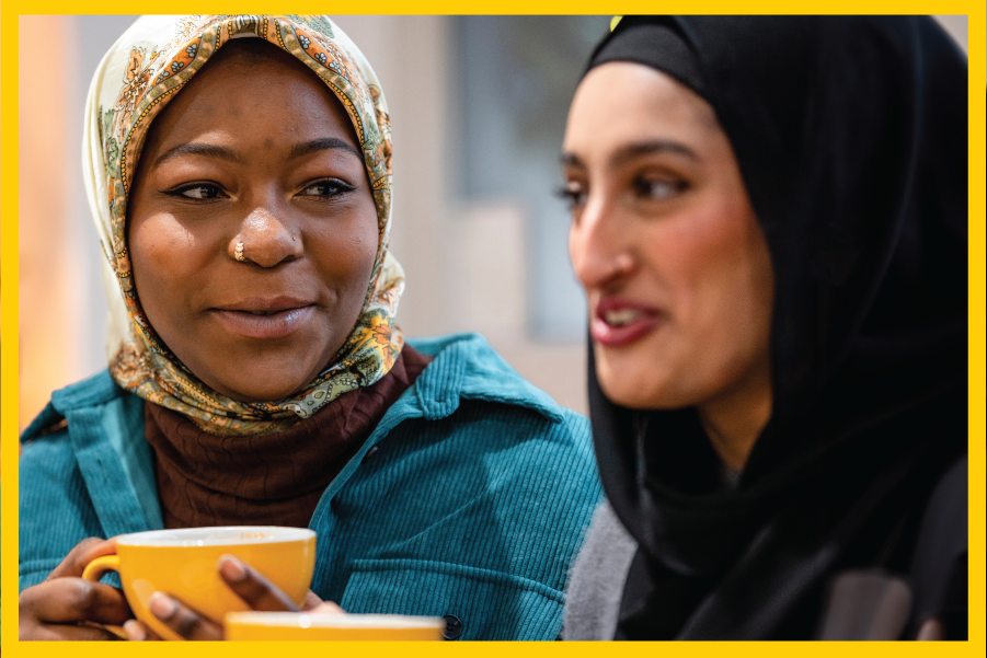 Two women have a conversation whilst having a hot drink