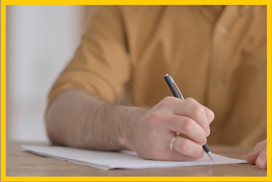 A close-up of someone's hand signing a legal document